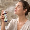 Kobieta odświeżająca twarz organicznym hydrolatem z szałwii w sprayu